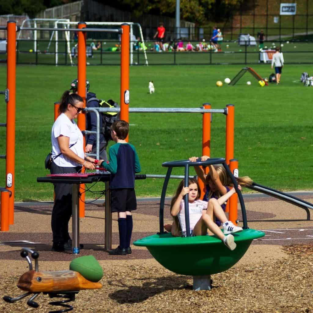 Children playing on the playground equipment at Tahurangi Crum Park in Titirangi, Auckland