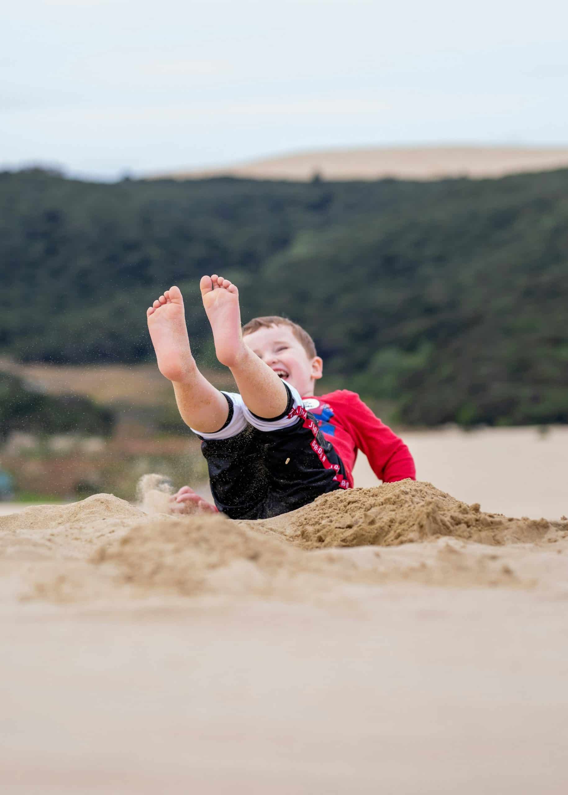 Boy playing in the sand at 90 Mile Beach in Northland, New Zealand