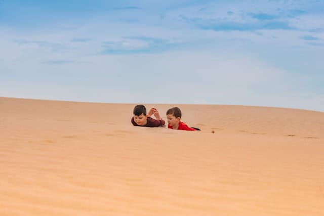 Children playing in the Sand dunes at Ninety Mile Beach, Northland, New Zealand