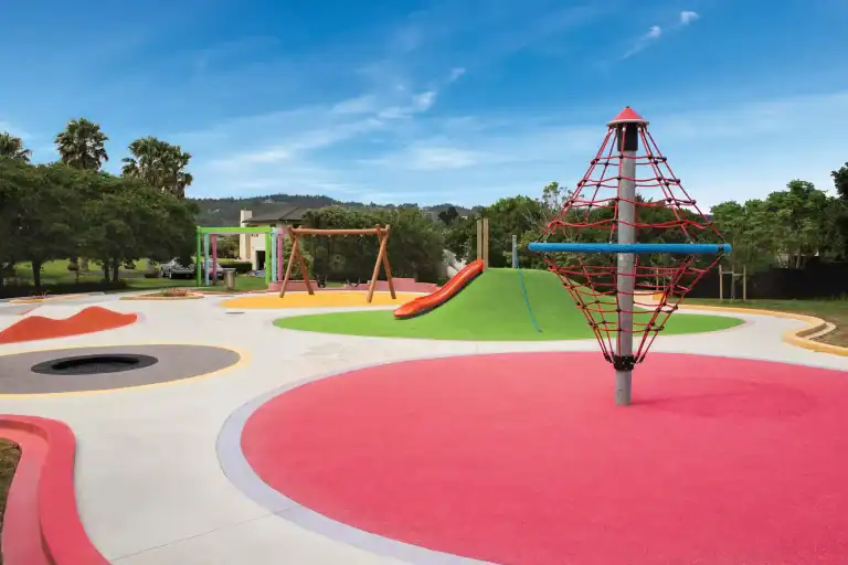 Rope climbing tower, trampoline, mound slide and colourful play zones at Sunny Crescent Playground in Huapai
