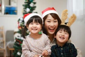 Smiling mother and children celebrating Christmas at home
