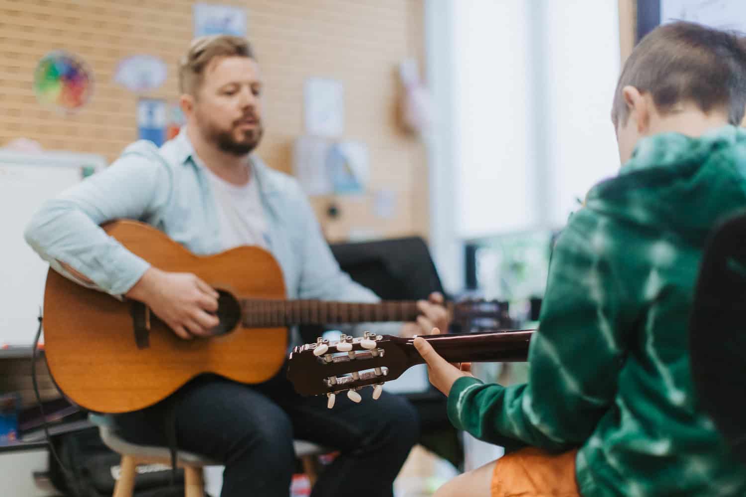 Modern Music Guitar Lesson Child learning to play the guitar with his music teacher at Modern Music School
