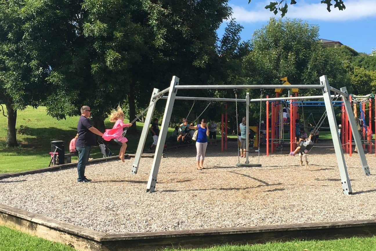 Children playing on the swings at Little Rangitoto Reserve, Remuera playground.
