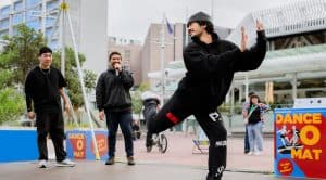 Street dancer performing in front of the Dance-O-Mat at Aotea Square with friends watching