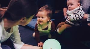 Young children and caregivers interacting during a gentle sensory theatre experience for babies.