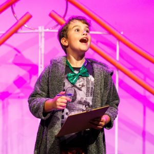 Child performing on stage at Kea Performing Arts youth theatre class