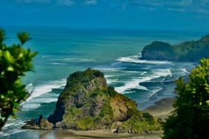 Lions Rock at Piha Beach on Auckland’s rugged west coast with waves and dramatic scenery