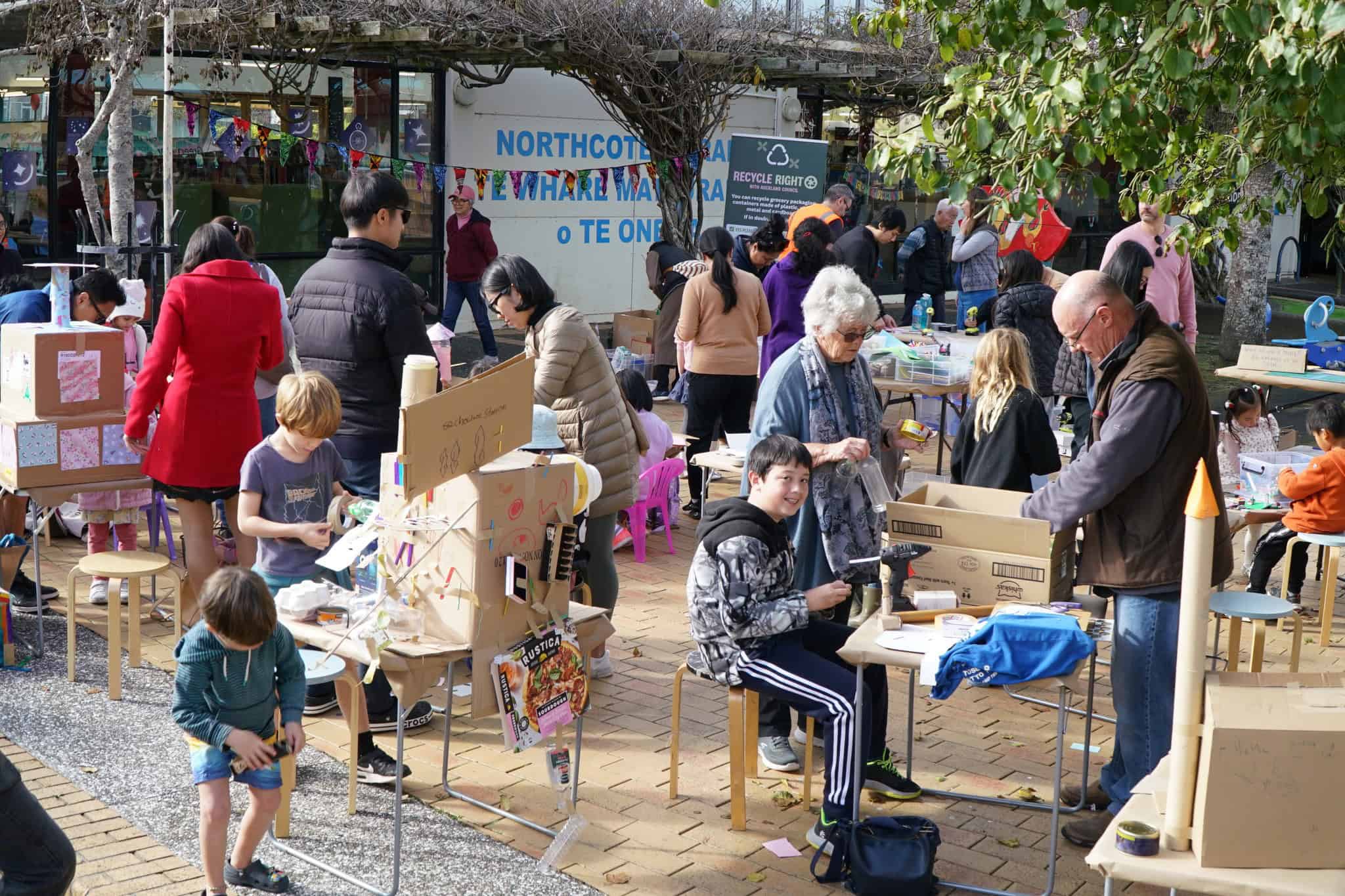 Children and families creating cardboard crafts together at the Crafty Christmas Upcycled City Edition event