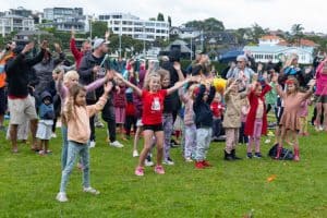 Children dancing on the grass at an outdoor Christmas carols event